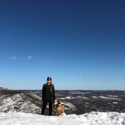 Hiker and dog on the summit of Storm King Mountain. Photo by Diana Richards.