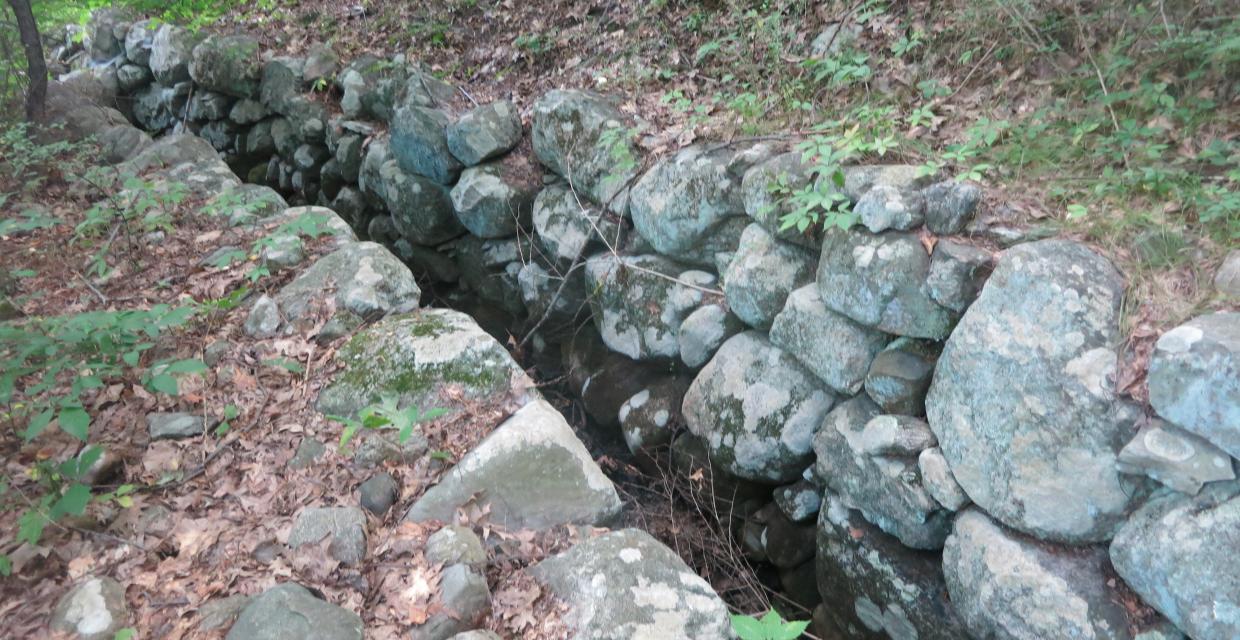 The stone-lined walls of an old mill race channel along the Marsh Loop Trail- Photo by Daniel Chazin