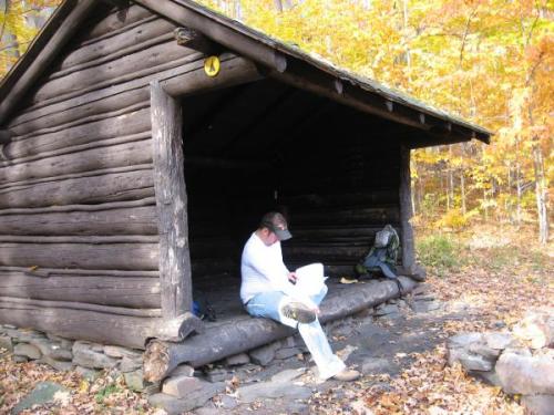 Man sits in Lean-to with notebook