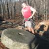 A hiker at a millstone at Camp Glen Gray.  Photo by Daniel Chazin.