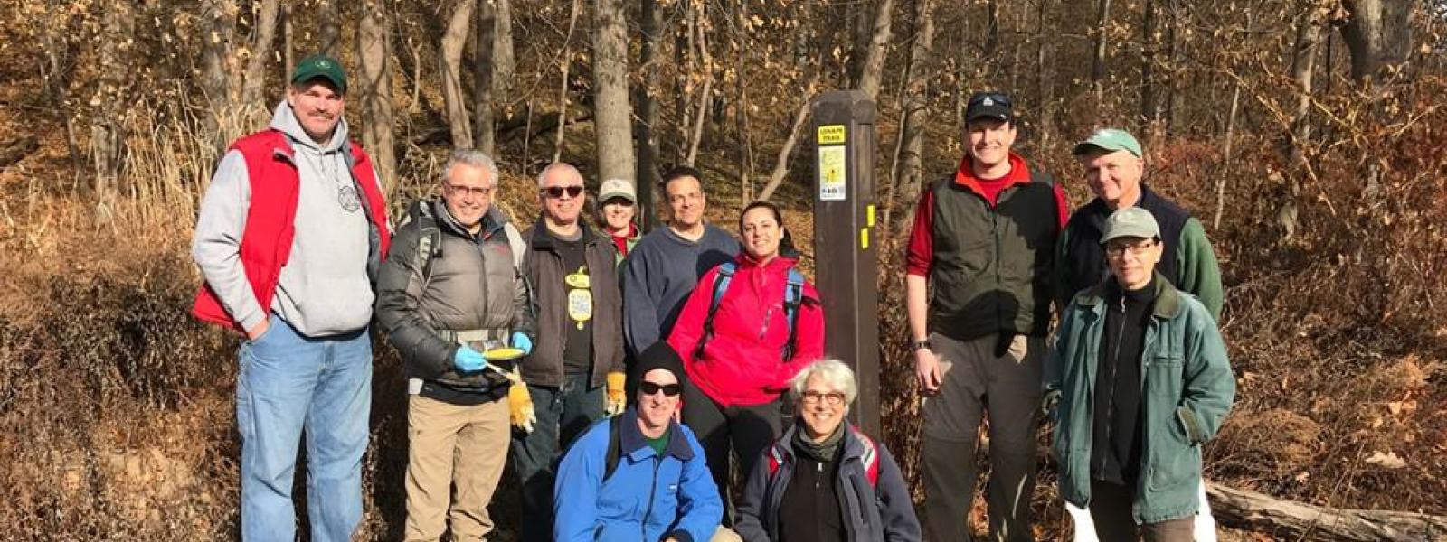 Proud volunteers pose by a new Lenape Trail sign bollard.