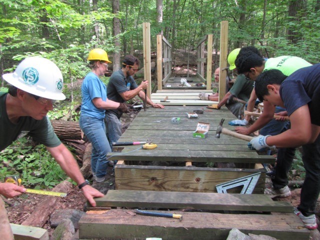 Volunteers repairing bridge.
