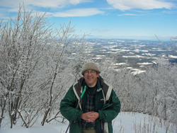Dan Chazin at the summit with northern view in the background.
