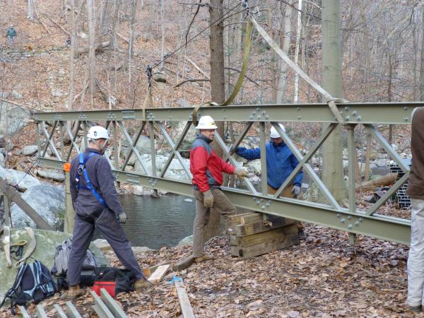 Volunteers prepare to "fly" a bridge truss into position.