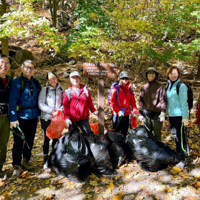 expert trail maintiners collecting trash along a popular hiking trail