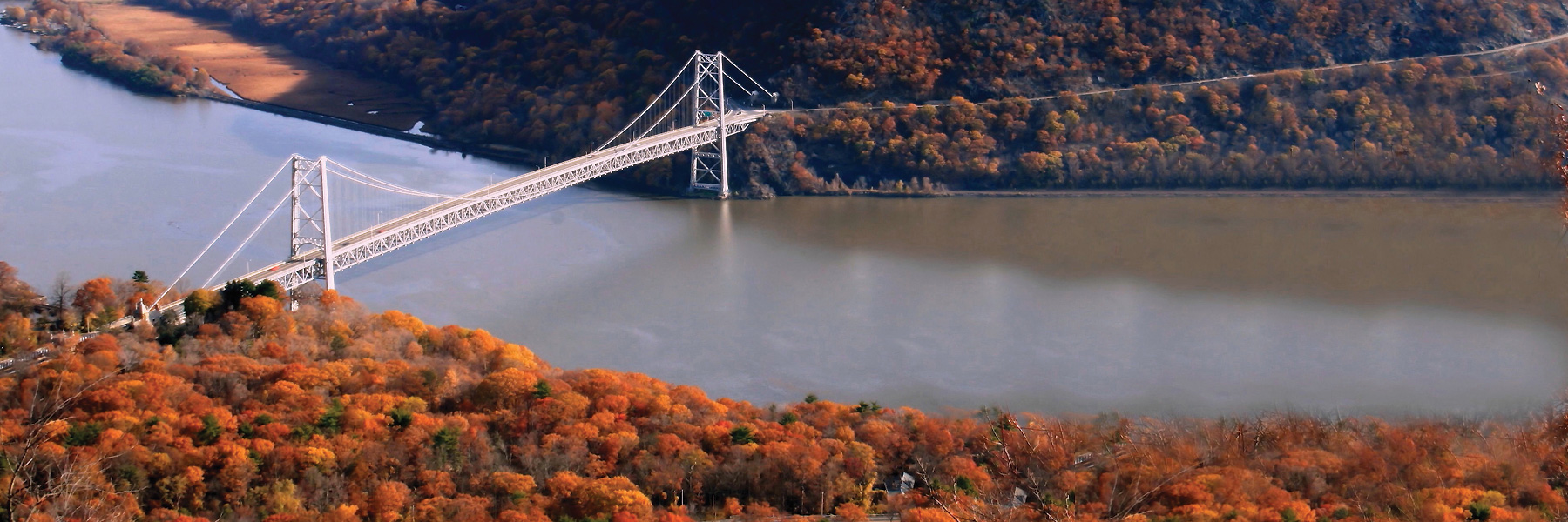 Member Hiking Clubs - Bear Mountain extension bridge over a fall landscape in new York