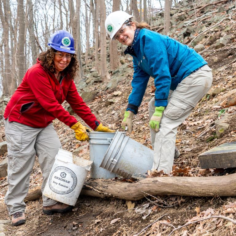Expert trail builders working on steps along steep trail.