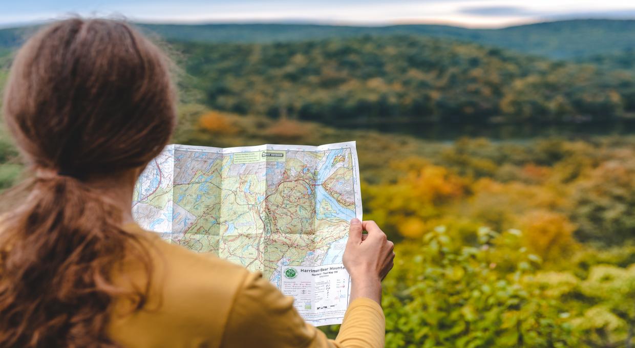 Over the shoulder view of a hiker reviewing a NYNJTC map
