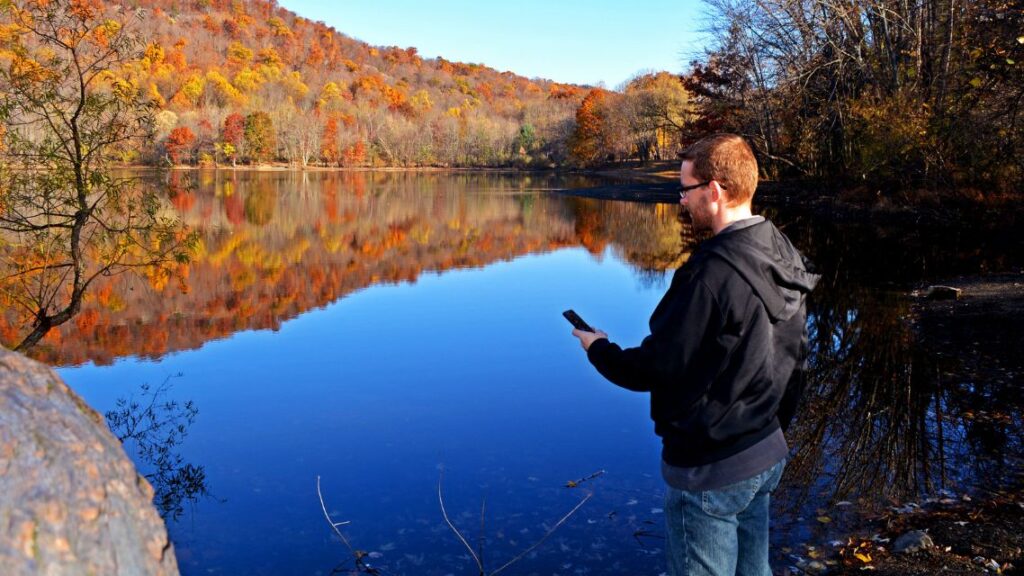 Avenza Trail Conference maps. A hiker uses a digital map for field navigation